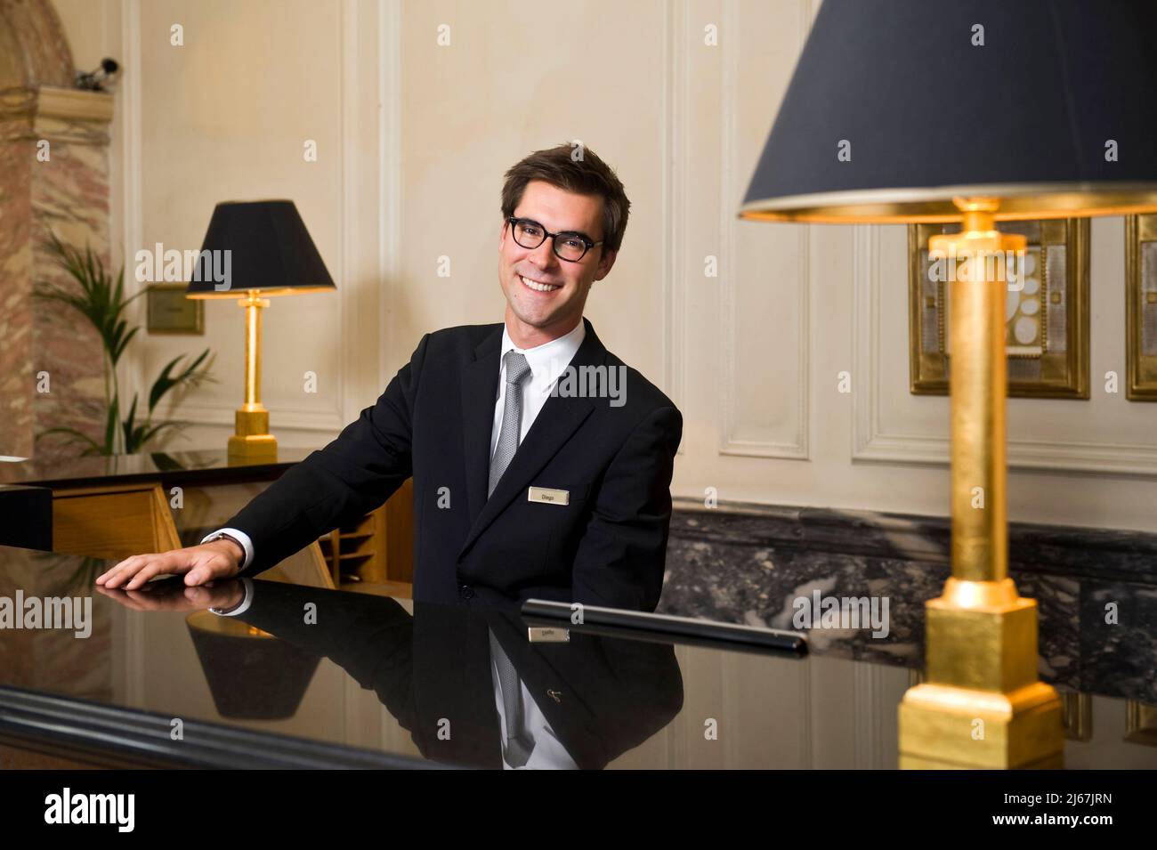 Concierge smiling from the hotel desk Stock Photo