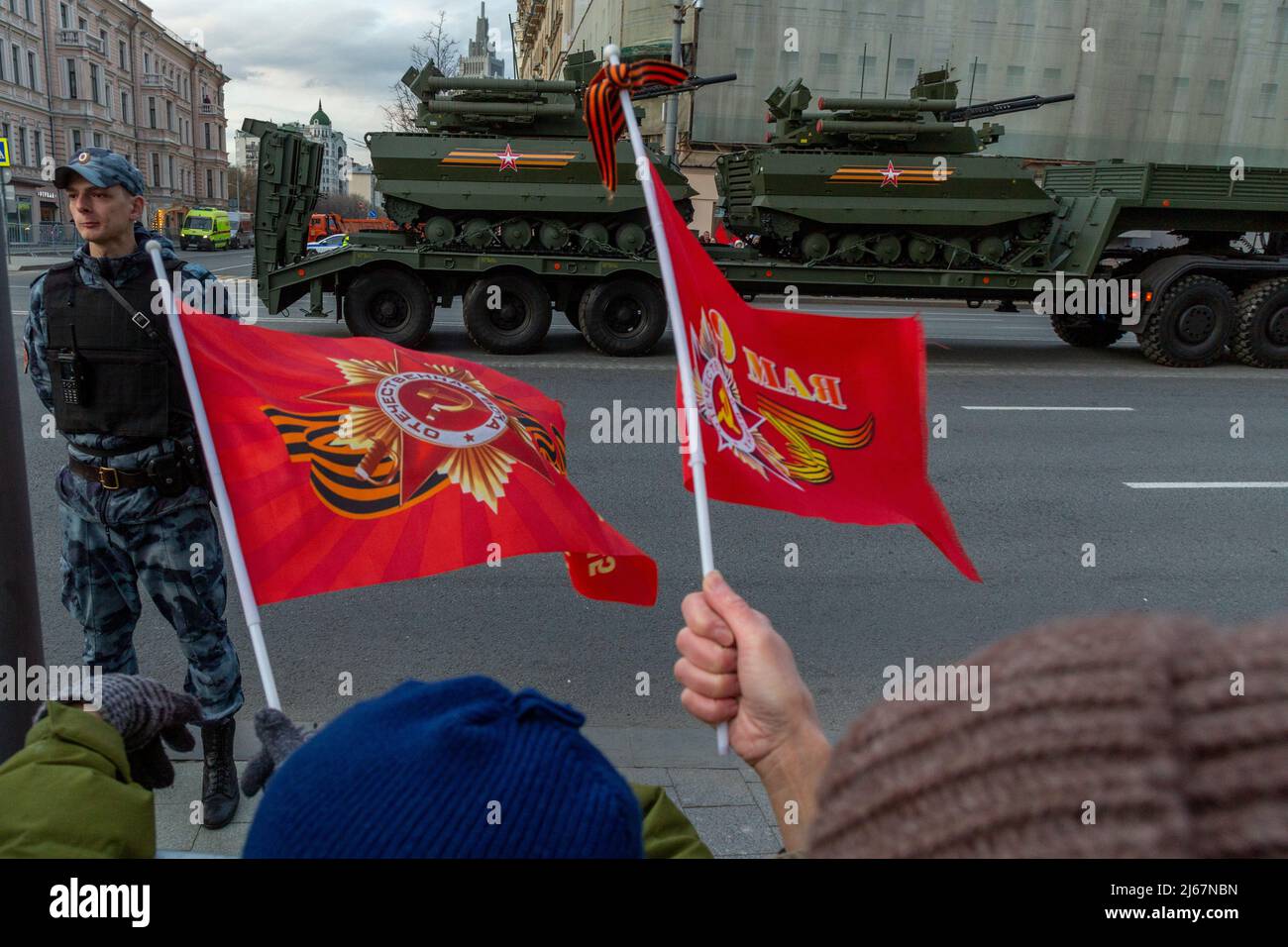 Moscow, Russia. 28th April, 2022. People watch military vehicles in Tverskaya Street as military hardware heads to Red Square for a rehearsal of the upcoming May 9 Victory Day parade marking the 77th anniversary of the victory over Nazi Germany in World War II. Credit: Nikolay Vinokurov/Alamy Live News Stock Photo
