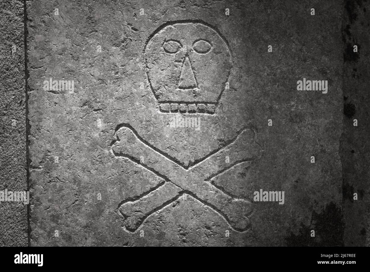 Skull and crossbones on the ancient tombstone. Sign of death Stock Photo
