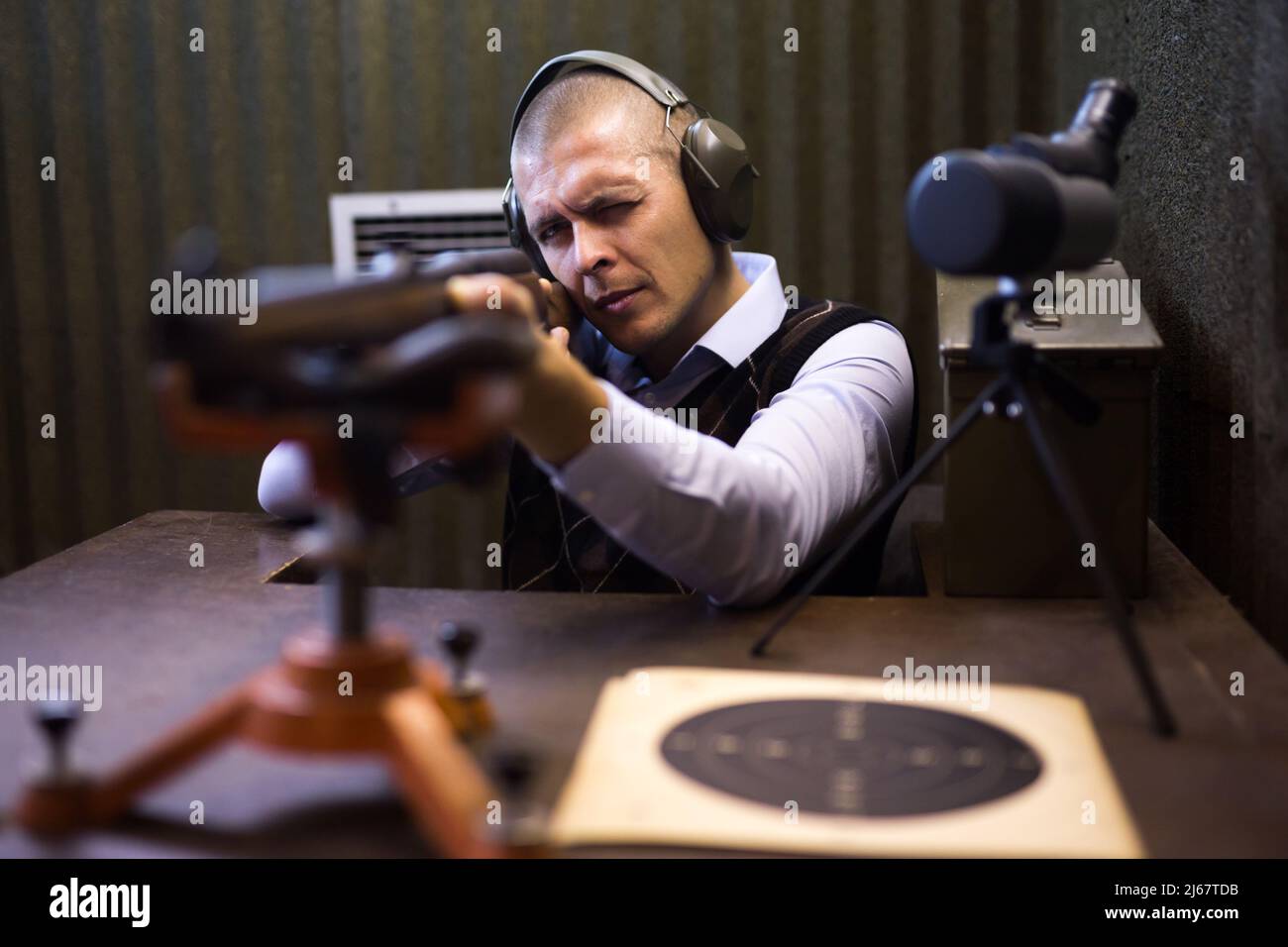 Shooter practicing shotgun shooting in sitting position at firing range