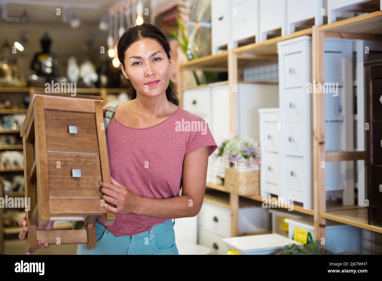 Woman choosing bedside table in store Stock Photo Alamy