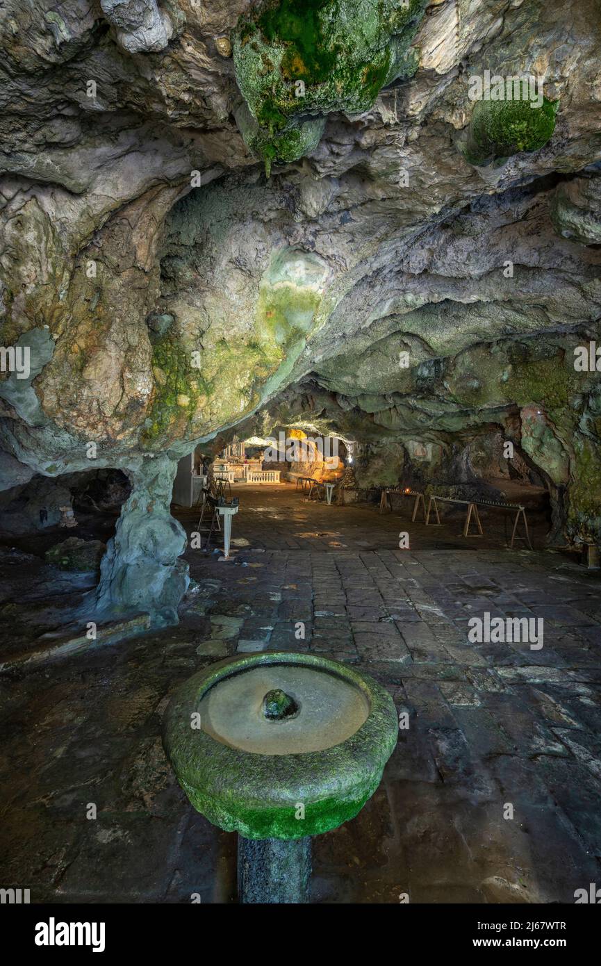 Main altar and holy water font in the cave of San Michele. Natural cavity dedicated since the Middle Ages to the cult of San Michele. Cagnano Varano Stock Photo