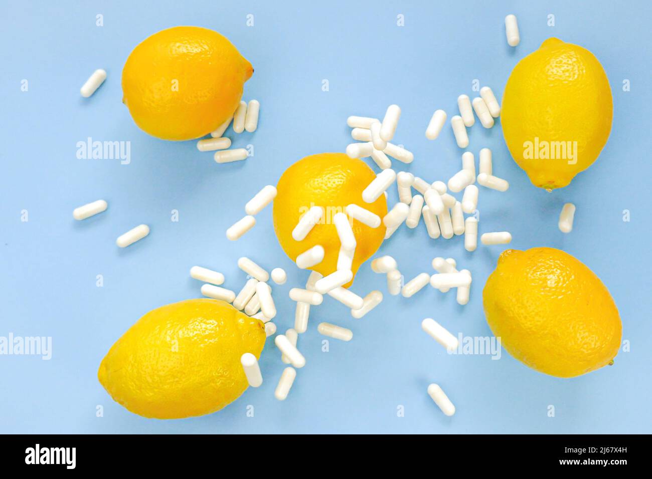 Vitamin C tablets and yellow lemons on a blue background.Natural Fruit