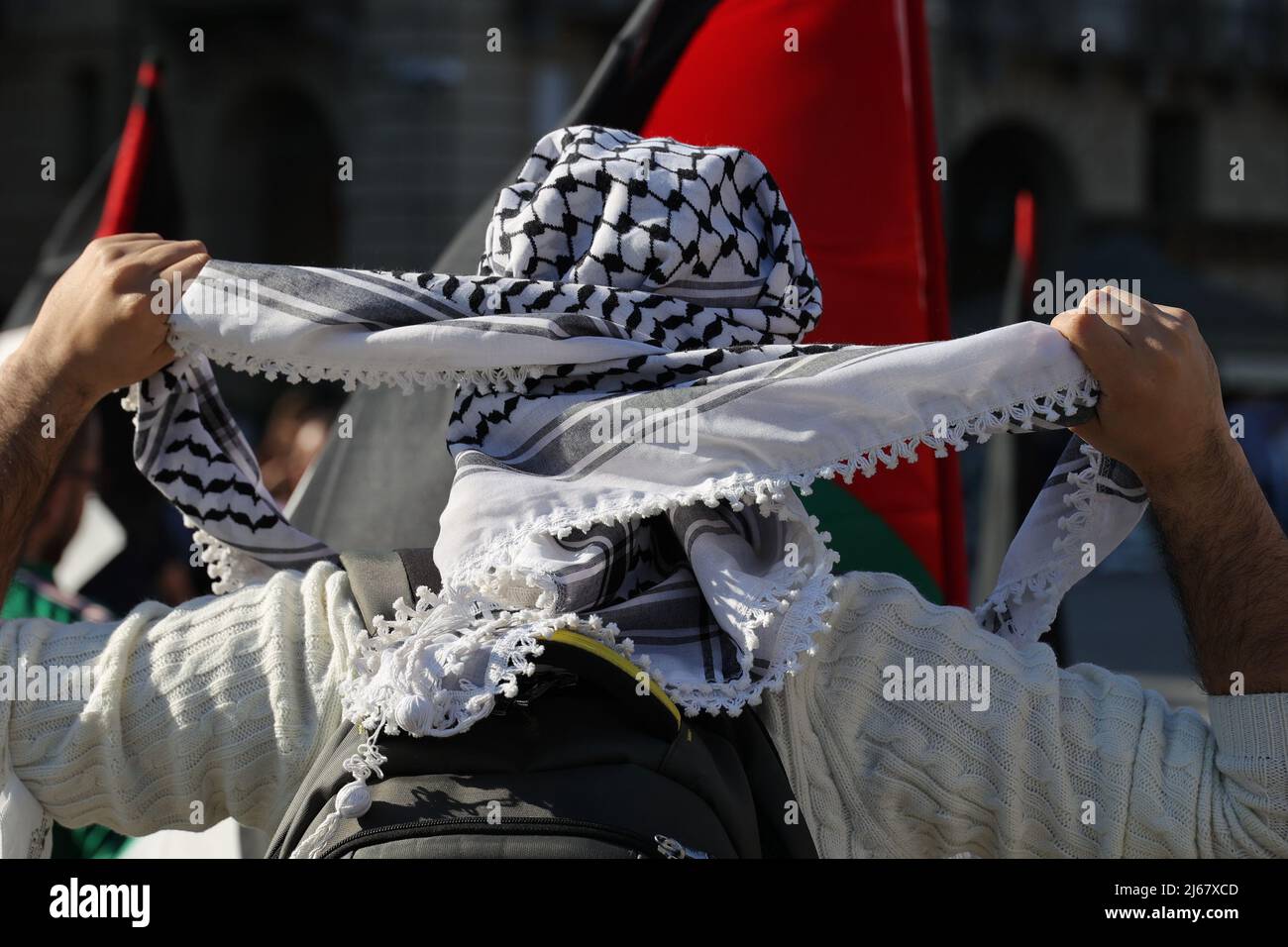 Turin, Italy. 28th April, 2022. A man ties his keffiyeh at a protest against the raids of Israeli forces in West Bank and restrictions on access to holy sites in Jerusalem during the Ramadan time. Credit: MLBARIONA/Alamy Live News Stock Photo