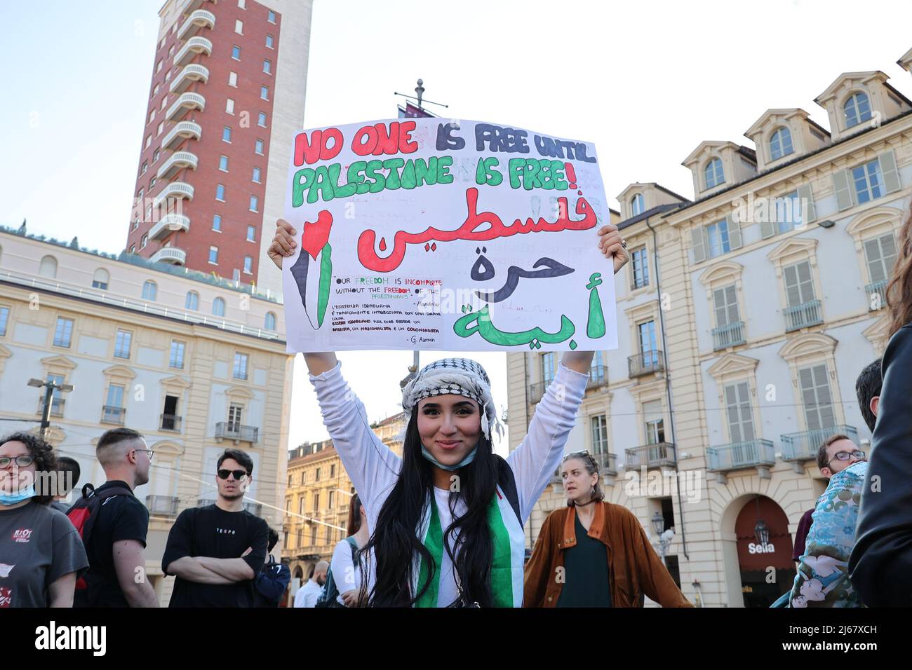 Turin, Italy. 28th April, 2022. A woman protests against the raids of Israeli forces in West Bank and restrictions on access to holy sites in Jerusalem during the Ramadan time holding a placard showing:“No one is free until Palestine is free”. Credit: MLBARIONA/Alamy Live News Stock Photo