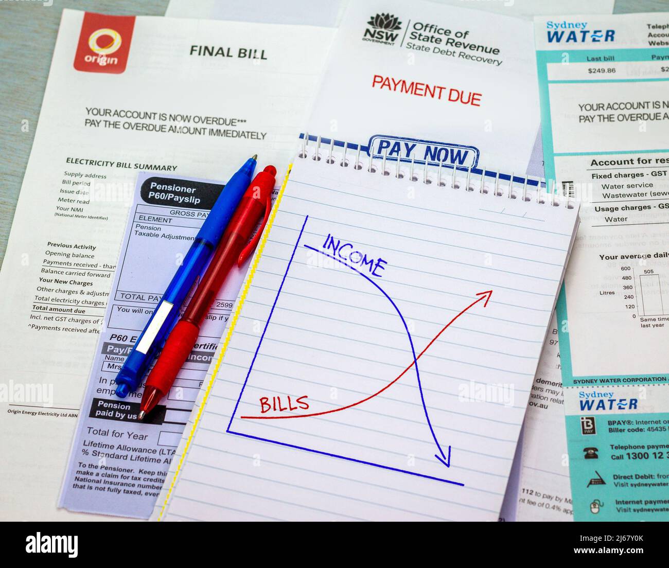 Cost of living, graph Income against Bills on note book with overdue utility bills. Increase in household expense. Stock Photo