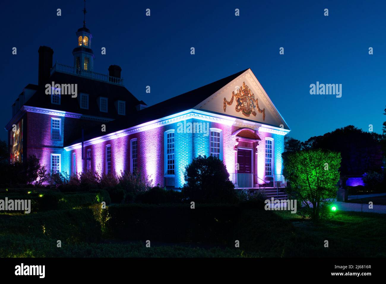 Governors Palace Garden View, CW Light show at night. Colonial Williamsburg. Colorful and dramatic spotlights surround the neoclassical architecture. Stock Photo