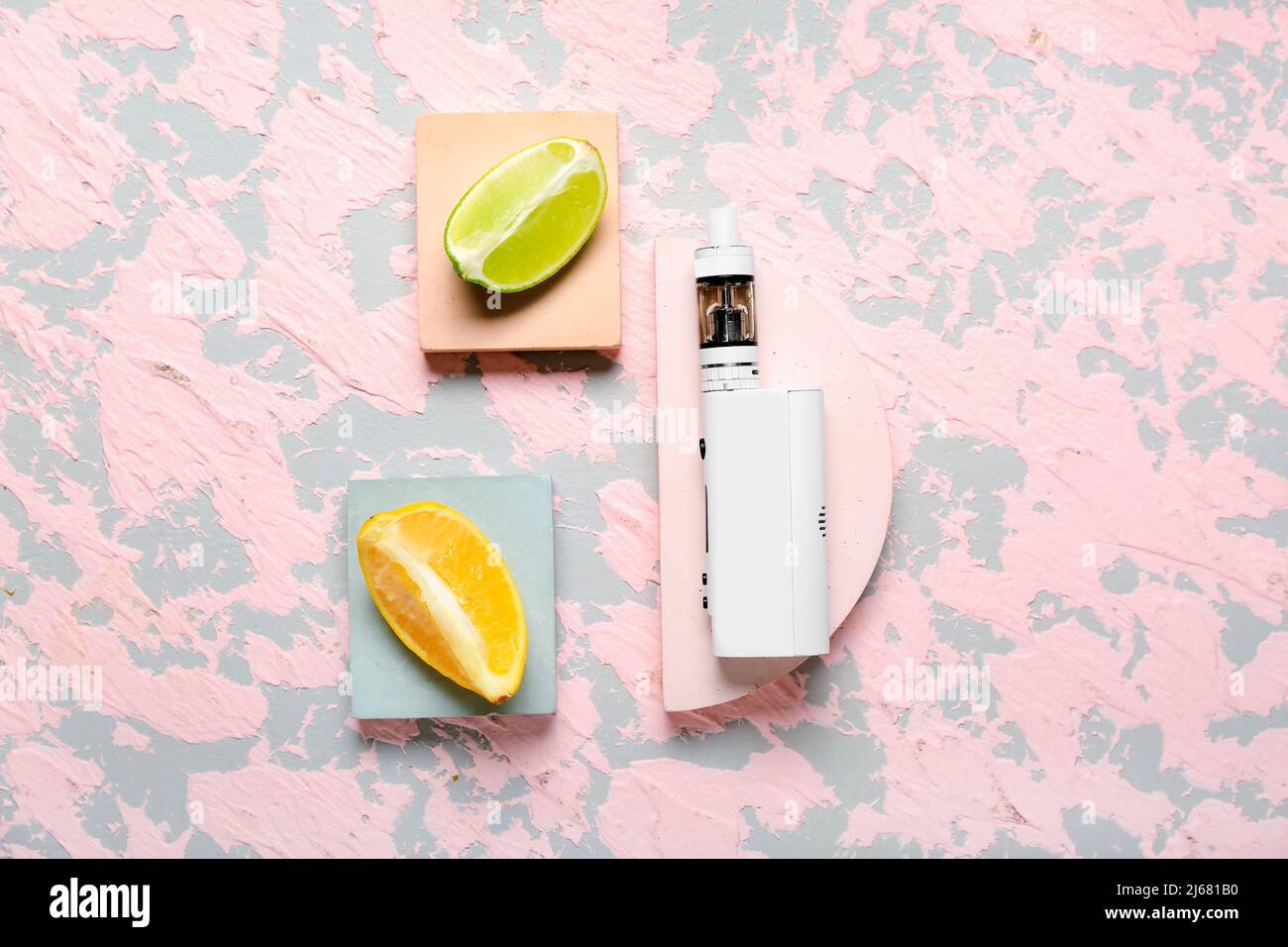 Modern vape mod and fruits on pink background Stock Photo - Alamy