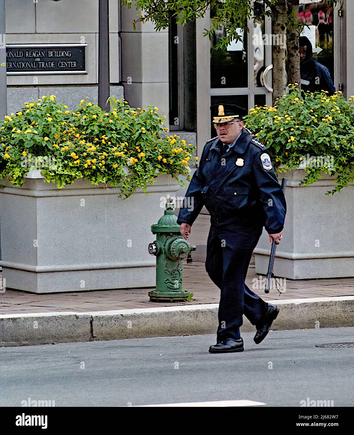 WASHINGTON DC - APRIL 20, 2002 Immigration rights protest march in Washington DC.  DC. Police Chief Charles Gainer carrying  his riot stick while he observes the action during a immigration rights march. Stock Photo