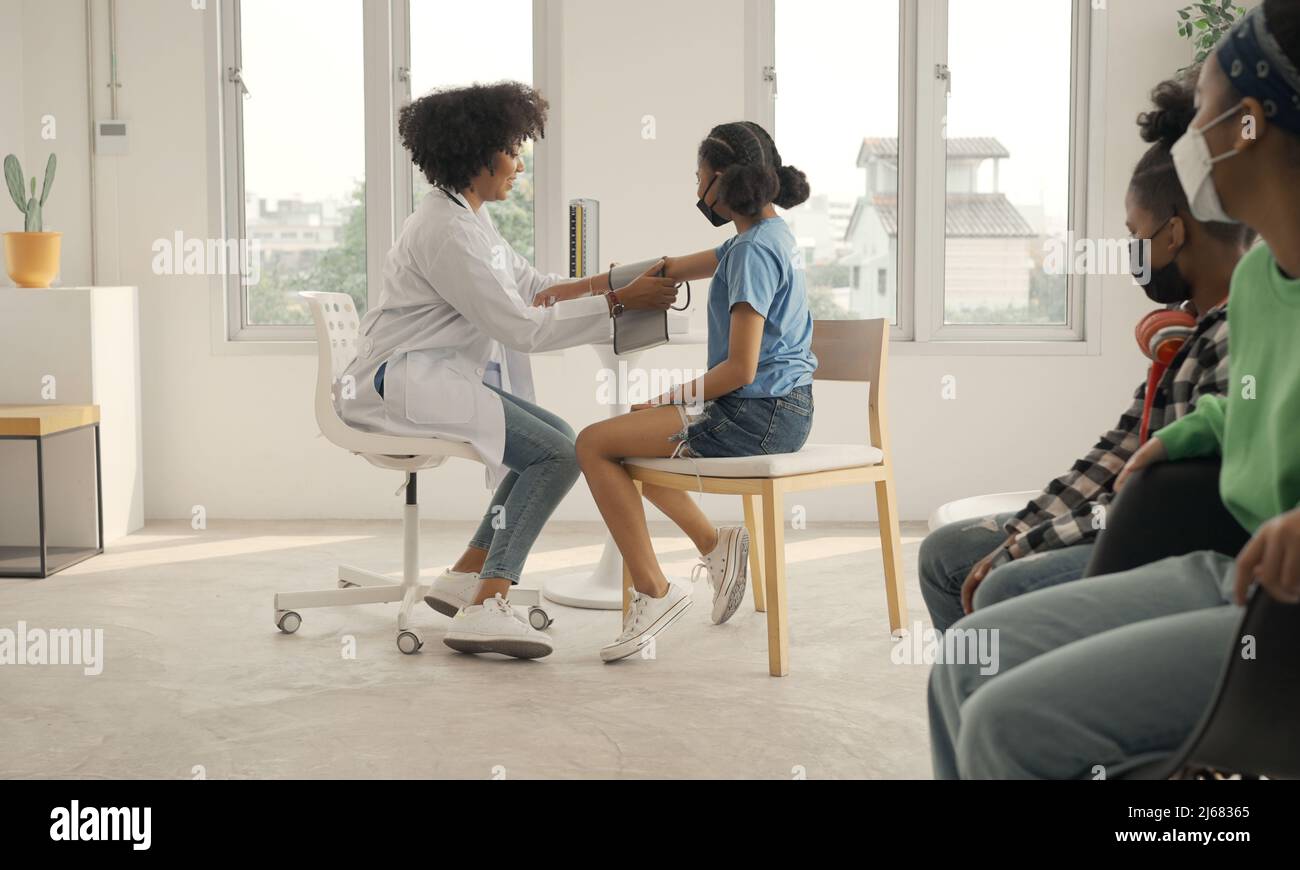 African american doctor is measuring blood pressure and checking pulse ...