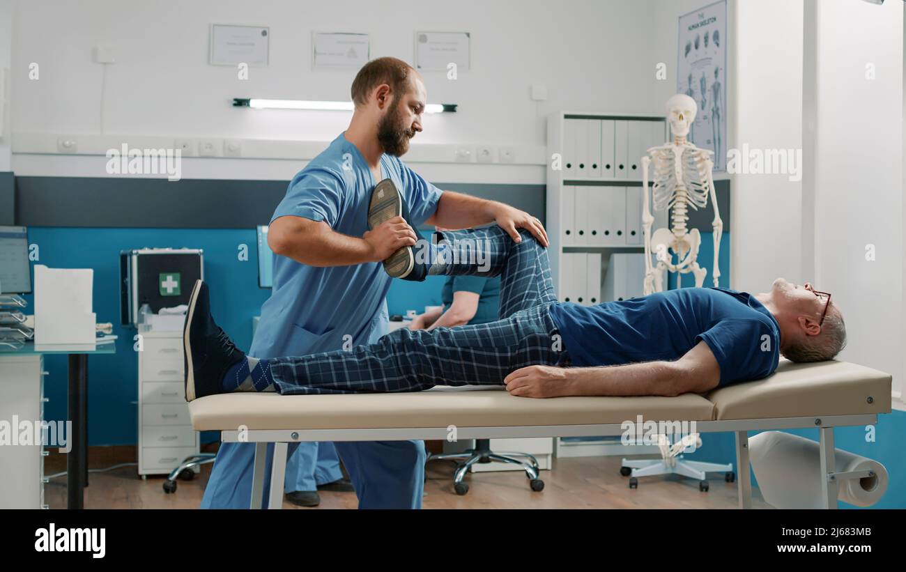 Therapist using legs raise exercise to stretch muscles and crack bones
