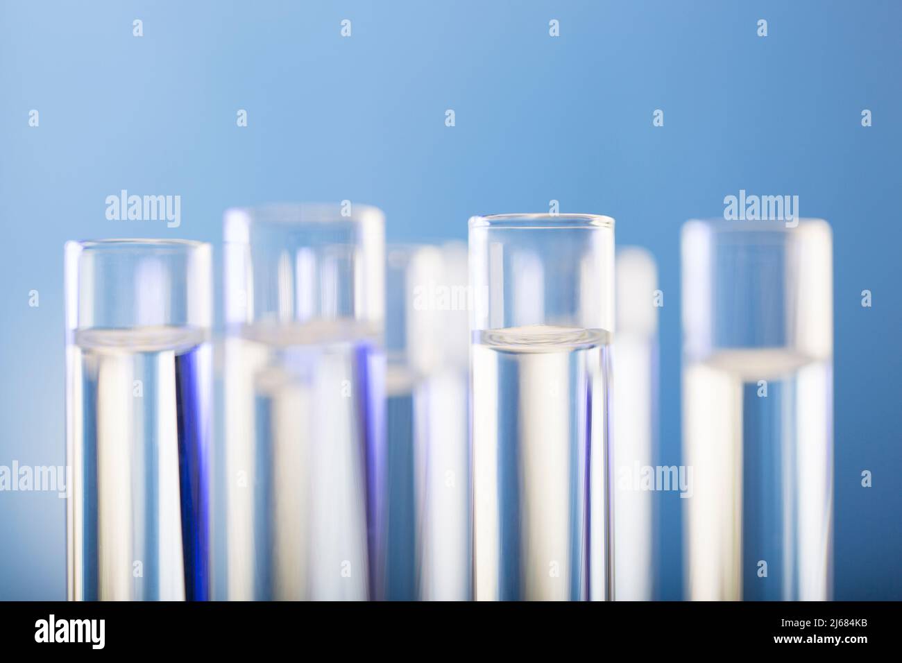 Neatly arranged test tubes containing clear reagent in chemistry laboratory - stock photo Stock Photo