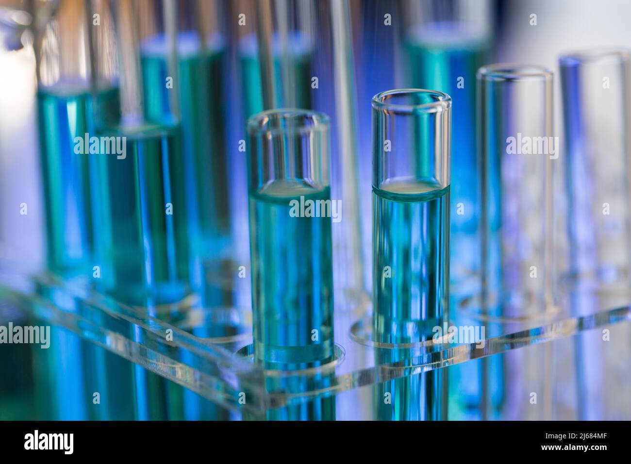 Neatly arranged test tubes containing blue reagent in chemistry laboratory - stock photo Stock Photo