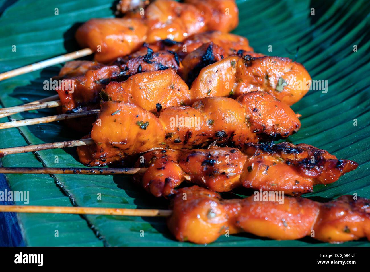 Thai street vendor sells grilled chicken meat at street food market in