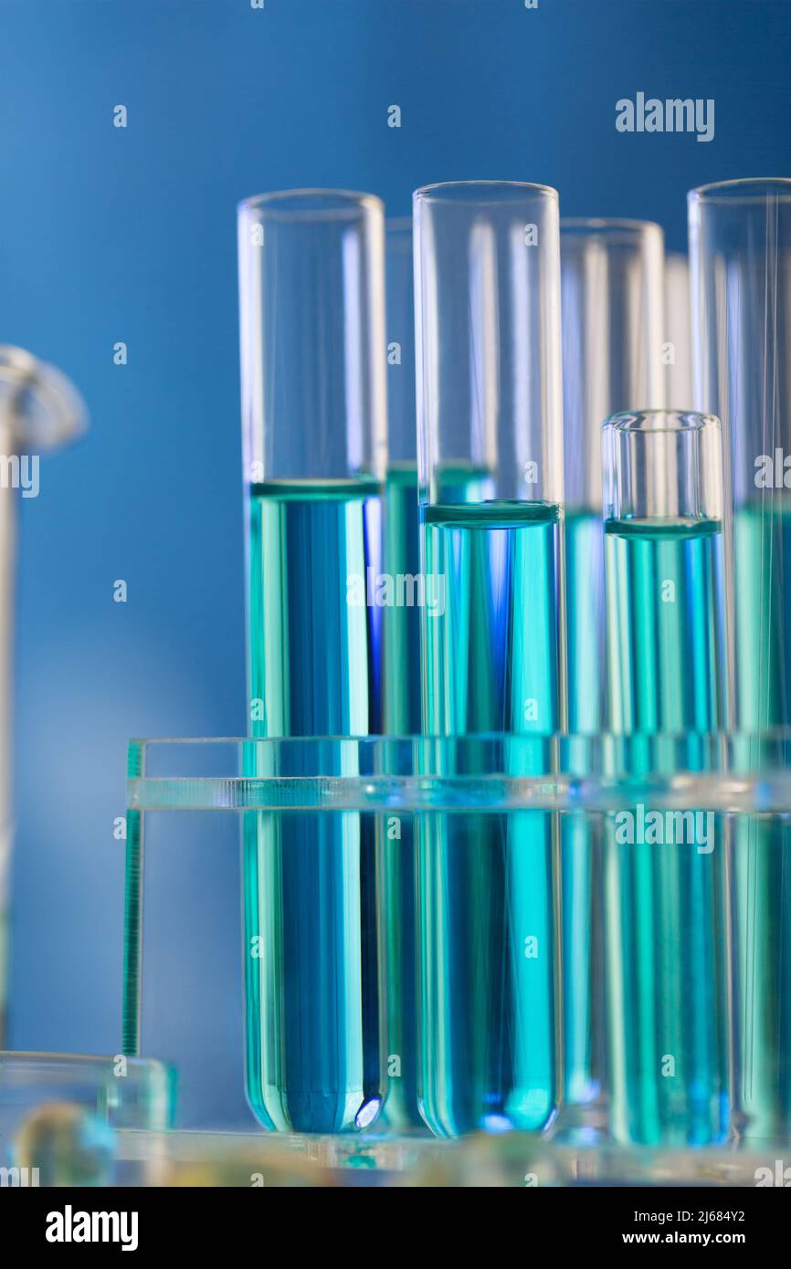 Blue tone, neatly arranged test tubes containing blue reagent in chemistry laboratory - stock photo Stock Photo