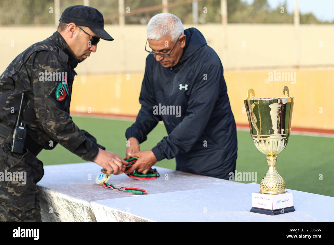 A judicial policeman appears as he presents the necklaces to the players of the Libyan team and the Nigerian team of the Football League to the inmates of Al-Sikt Prison in Misurata. Stock Photo