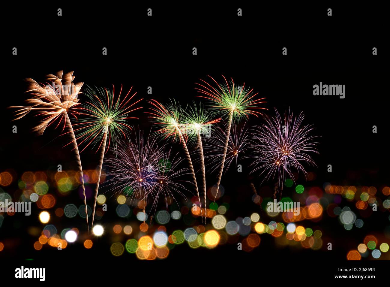 Colorful fireworks celebration and the city night light background on midnight sky. Stock Photo