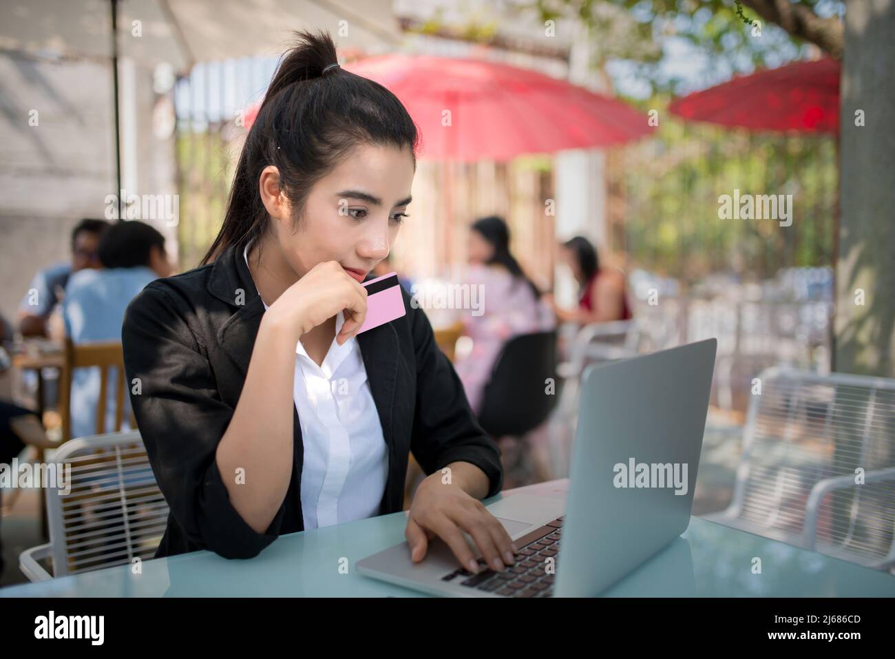 Busy young business woman working on desk using laptop in coffee shop Stock Photo