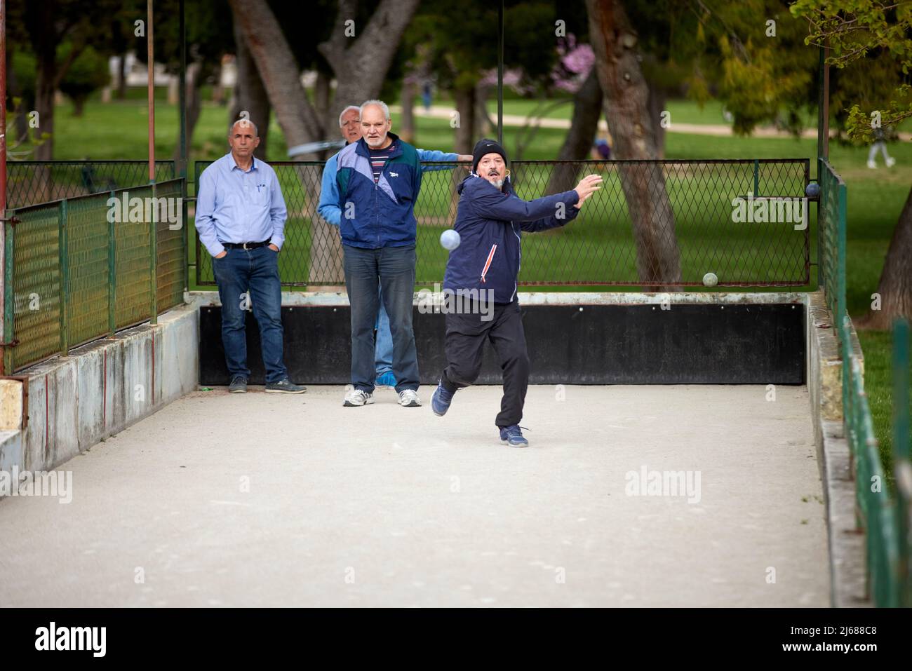 The city of Split in Croatia in the region of Dalmatia, older gentleman playing bocce ball in a public park Stock Photo