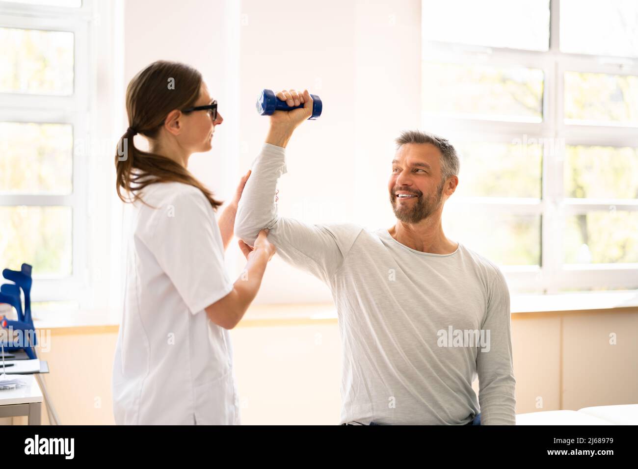 Physical Rehabilitation Therapist Helping Man. Physiotherapy Rehabilitation Stock Photo