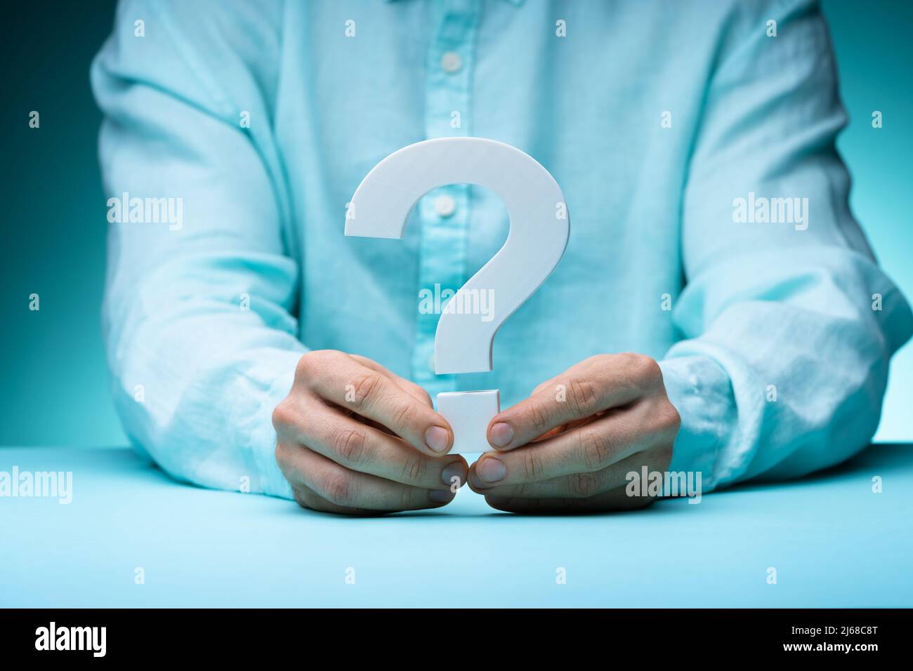 Confused Man Holding Question Mark. Problem And Answer Stock Photo