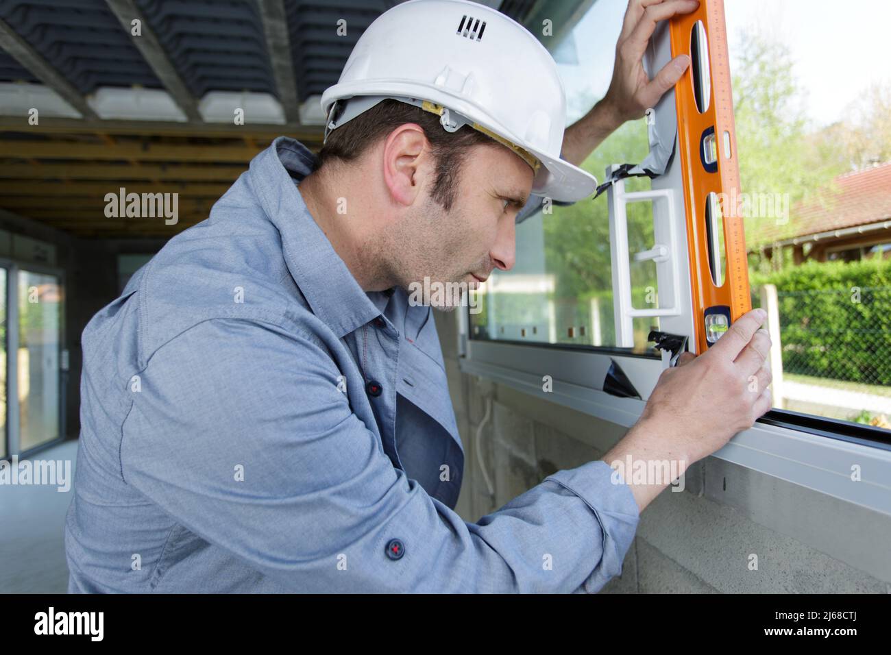 mature worker checks the level of a window Stock Photo - Alamy