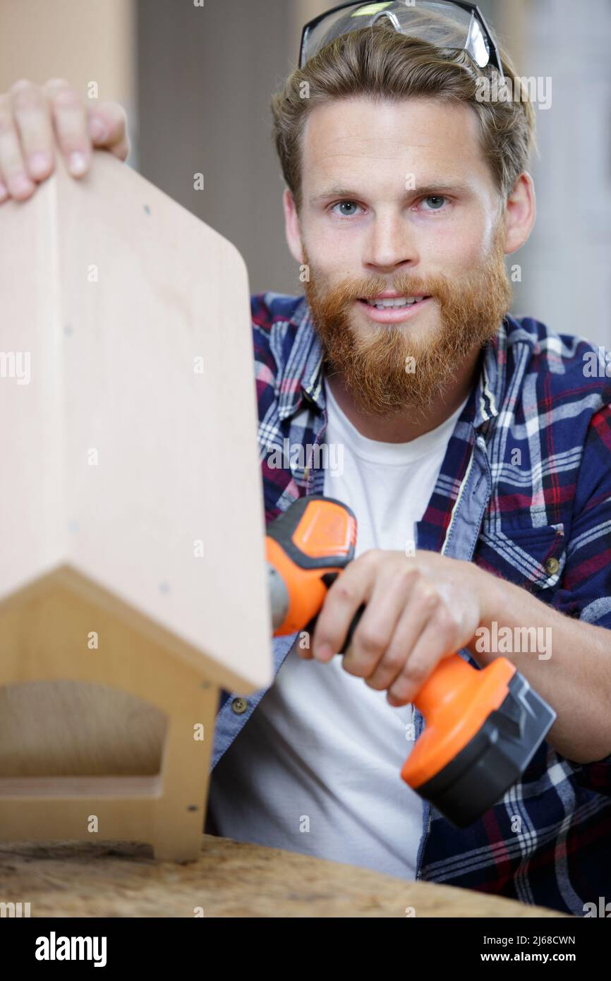 men in home clothes work with a screwdriver Stock Photo