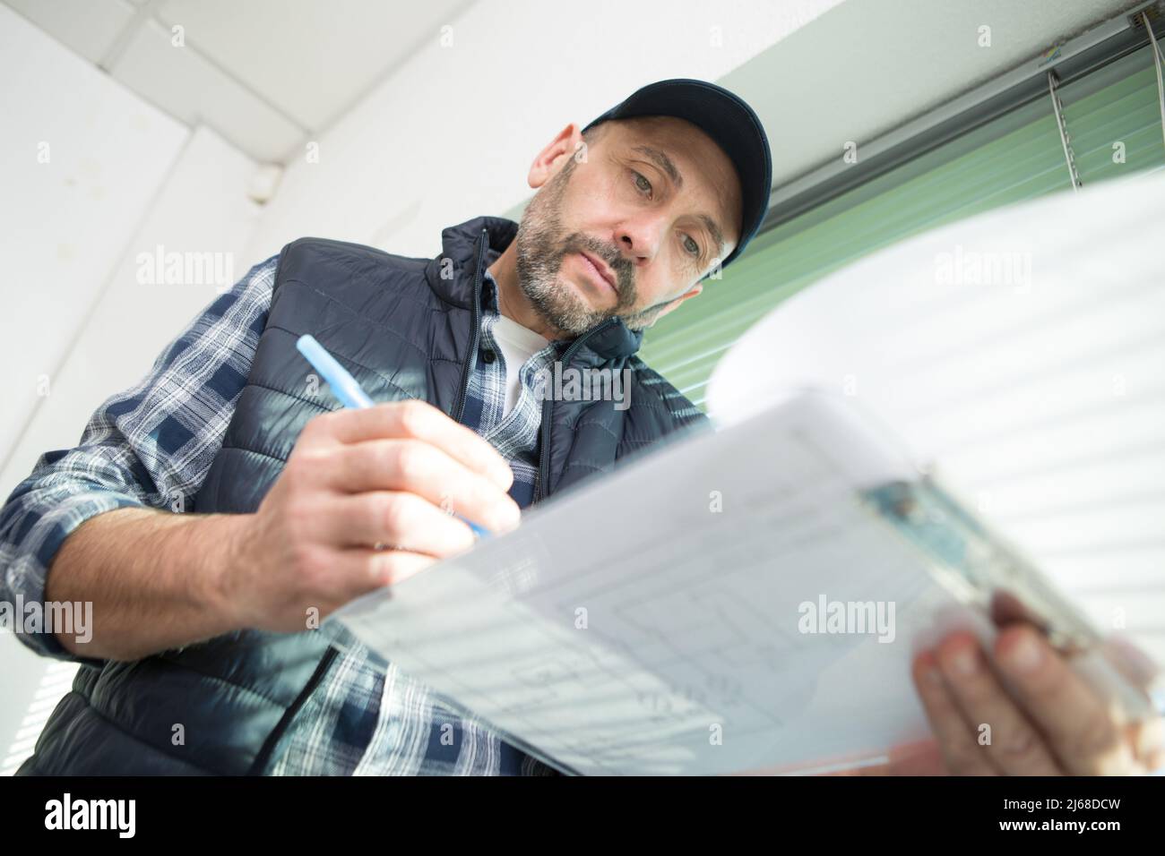 man writing something on clipboard isolated on white background Stock ...