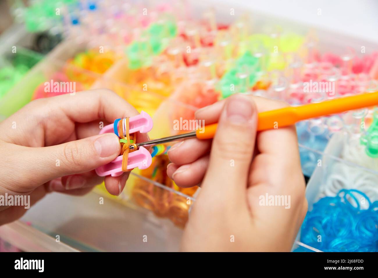 Rubber Band Weaving. Knitting rubber bands with loom knit. Hands of