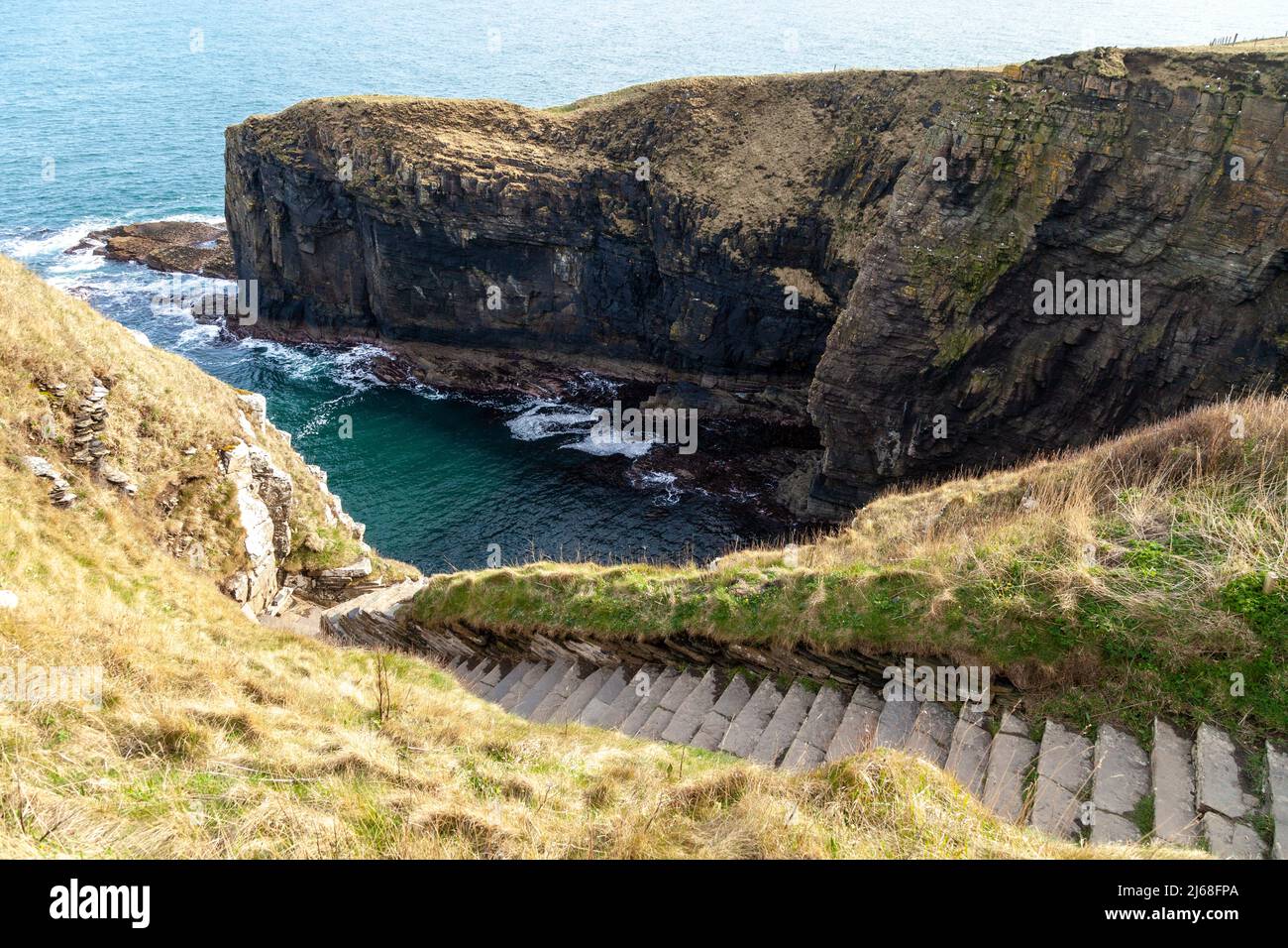Whaligoe Steps zigzag down the 250ft cliff face to give you access to Whaligoe Haven Stock Photo