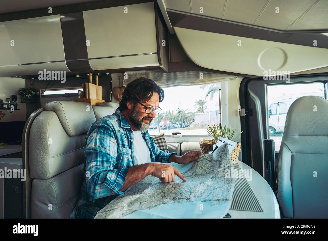 Nomadic traveler lifestyle adult mature man inside a camper van Nomadic traveler lifestyle adult mature man inside a camper van