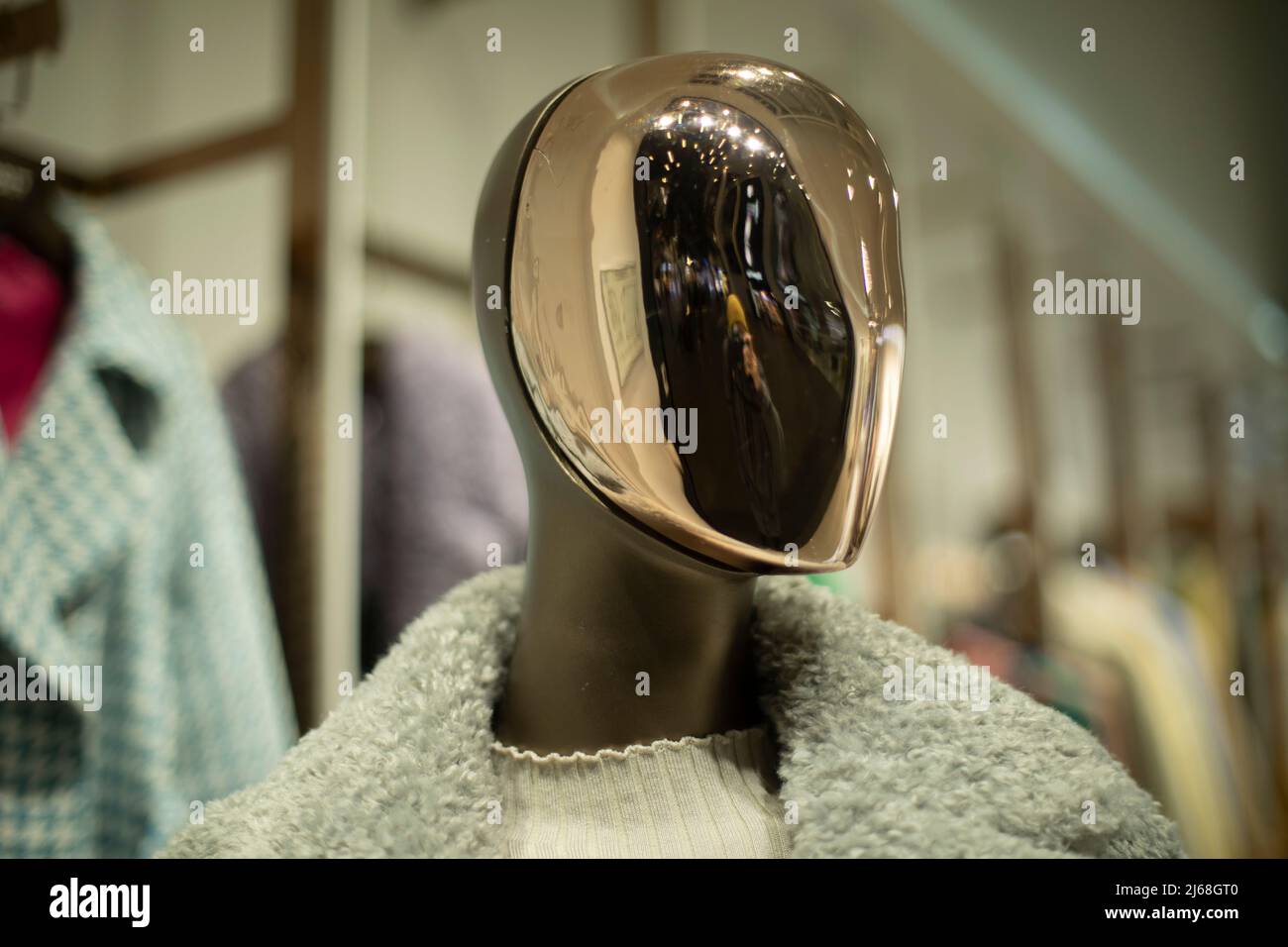 Golden mask on face of mannequin. Details of style and fashion. Mannequin in clothing store. Female figure. Stock Photo