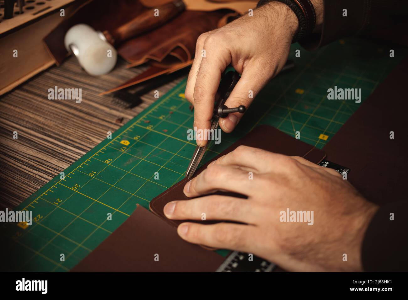 leatherworker embossing. Tanner works with leather Stock Photo