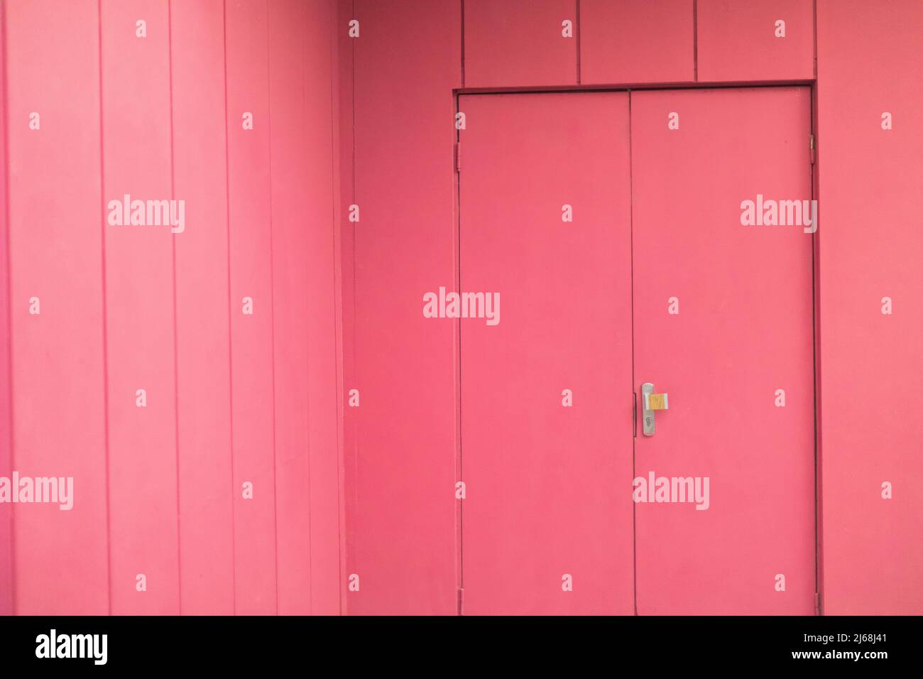 Pink interior. Door to hall. Painted walls. One color of walls. Stock Photo