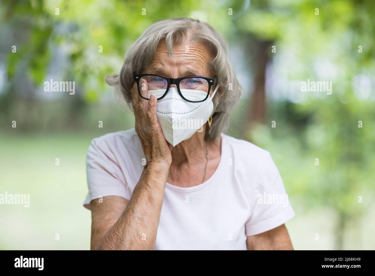 Elderly woman wearing a protective face mask against corona virus Stock Photo