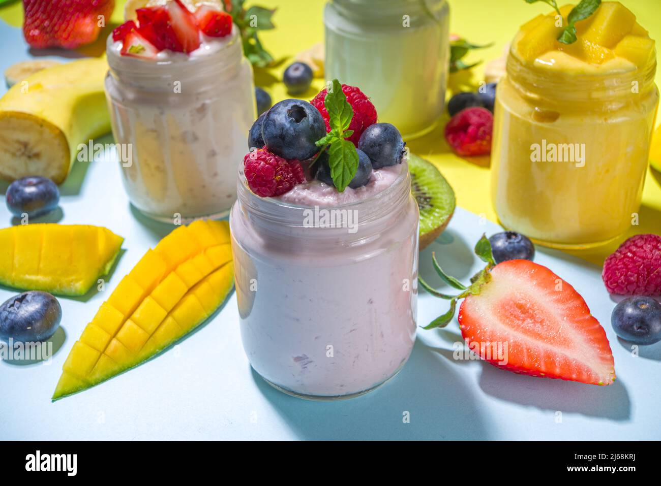 Set of various fruit and berry yogurts in glass jars. Variety healthy