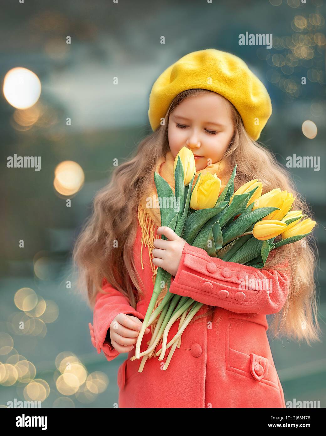 Portrait of a happy girl with a bouquet of yellow tulips on a walk in spring. Flowers for International Women's Day. Stock Photo