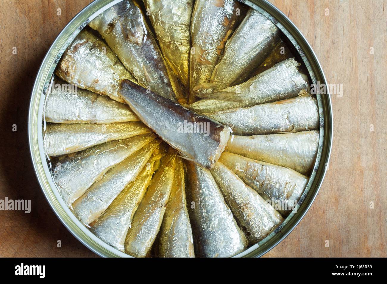 Sardines can close up on an old weathered wooden background. Storage food and fish. Stock Photo