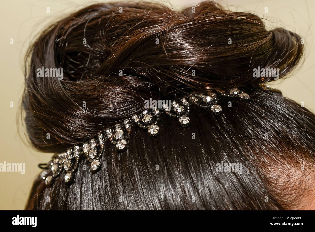 A rhinestone embellishment in the hairstyle of a black-haired bride on her wedding day. Stock Photo