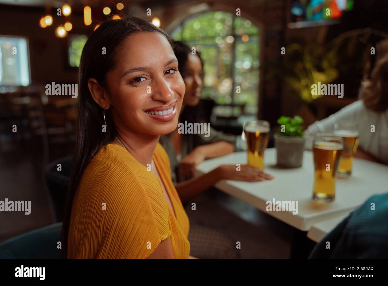 african american female smiling while enjoying evening with friends Stock Photo
