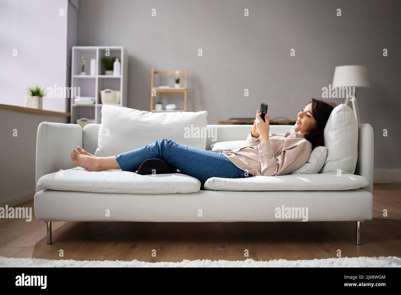 Woman Using Footrest To Reduce Back Strain And Feet Fatigue Stock Photo