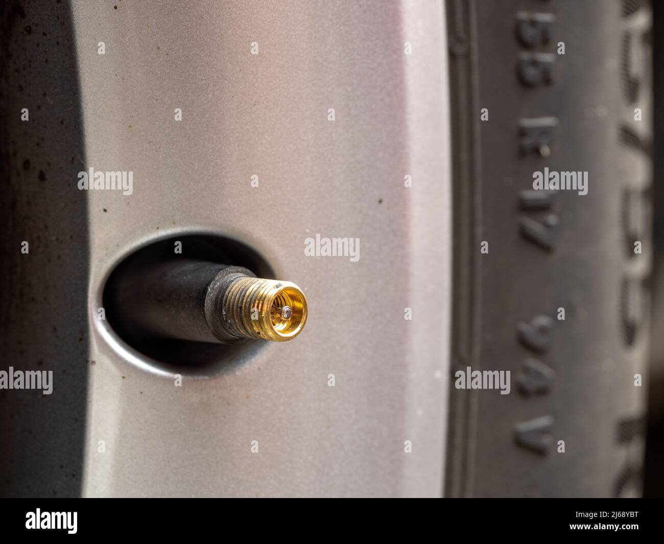Selected Focus Dirty Alloy wheel and tire with air pressure pump valve Stock Photo