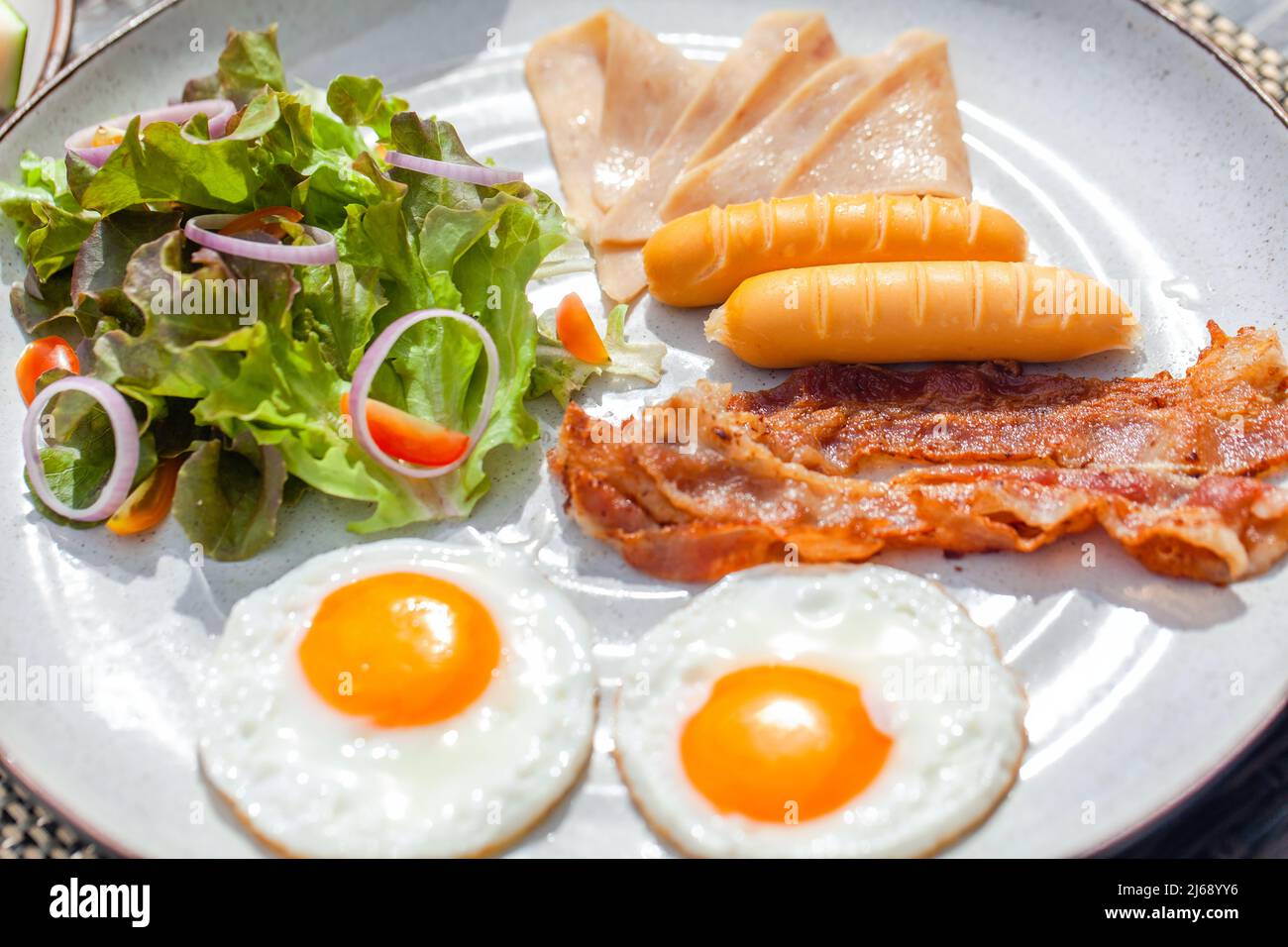 American breakfast with two sunny eggs at outdoor restaurant in hotel Stock Photo