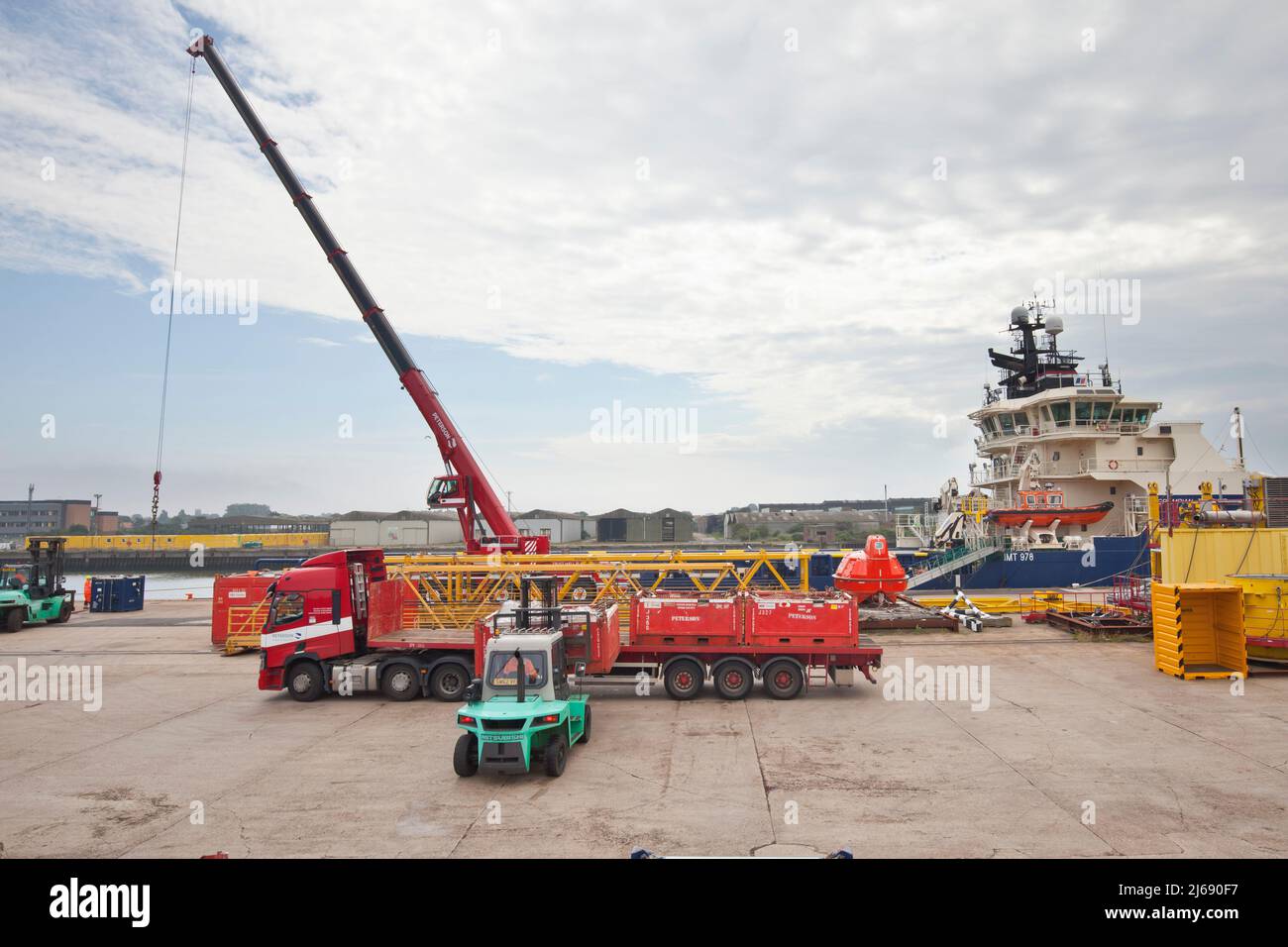 Loading and unloading of North Sea supply vessel, using 5 and 10 tonne Mitsubishi forklifts on Peterson's quay at Lowestoft. Stock Photo