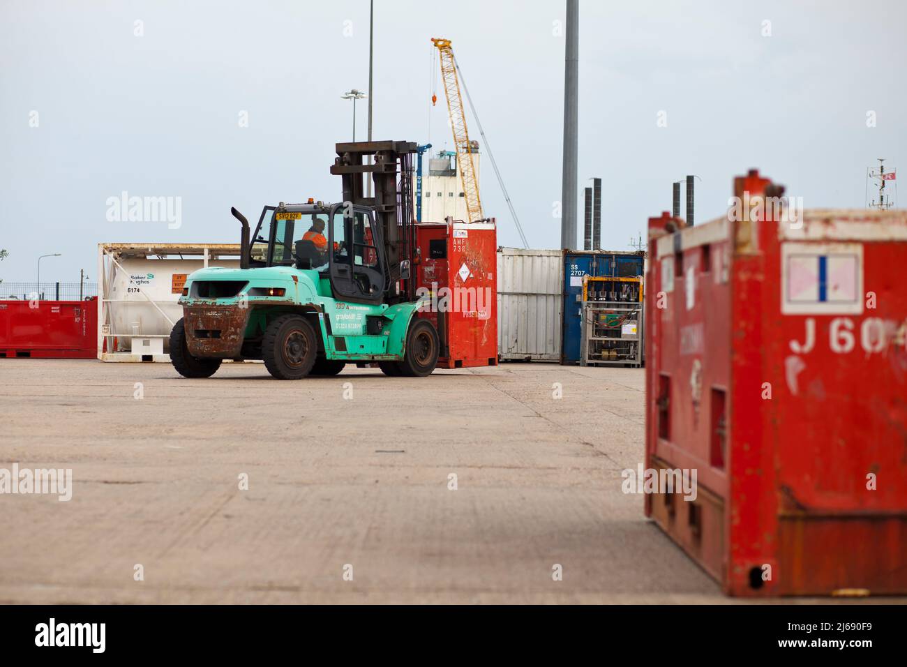 Loading and unloading of North Sea shipping containers using 5 and 10 tonne Mitsubishi forklifts on Peterson's quay at Lowestoft. Stock Photo