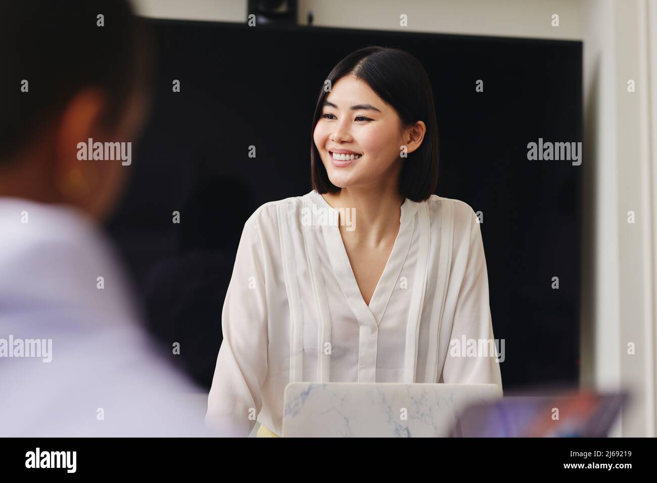 Portrait of cheerful mid adult Chinese businesswoman smiling in business meeting with confident expression Stock Photo