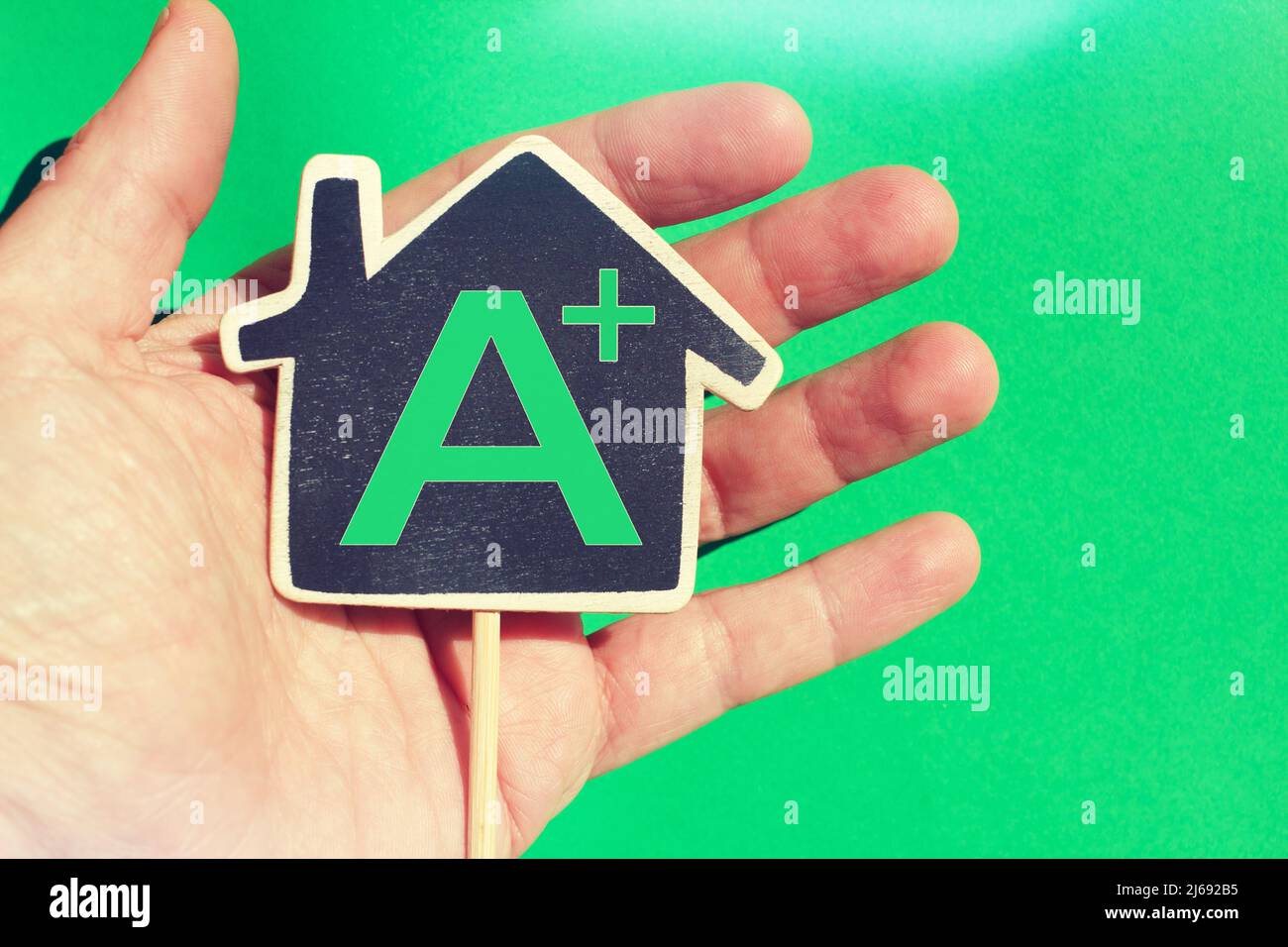 Hand holding a house with the text "A+" concept of house with a