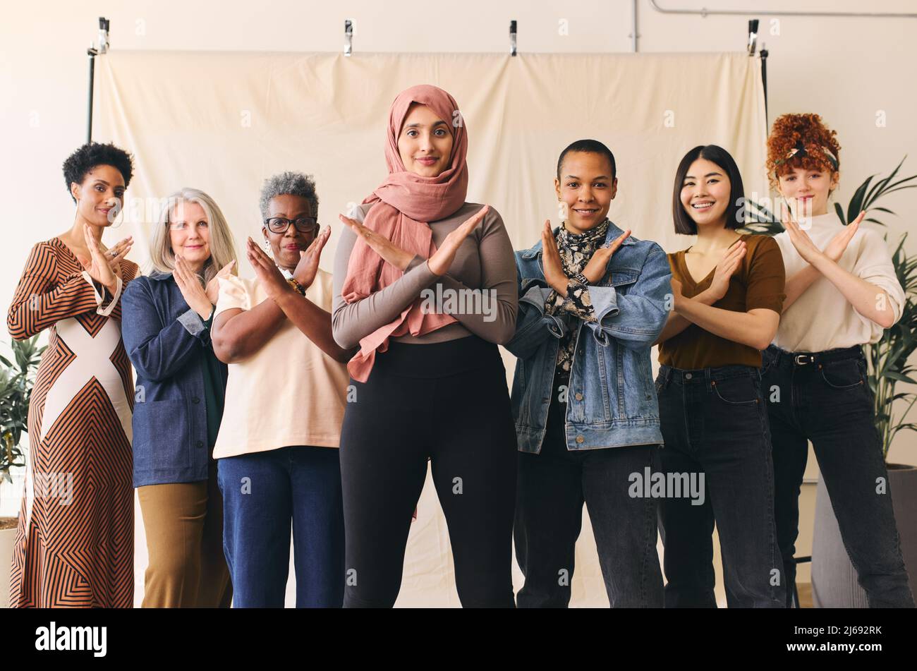 Middle Eastern woman wearing hajib gesturing Break The Bias in support of International Women's Day with female friends Stock Photo