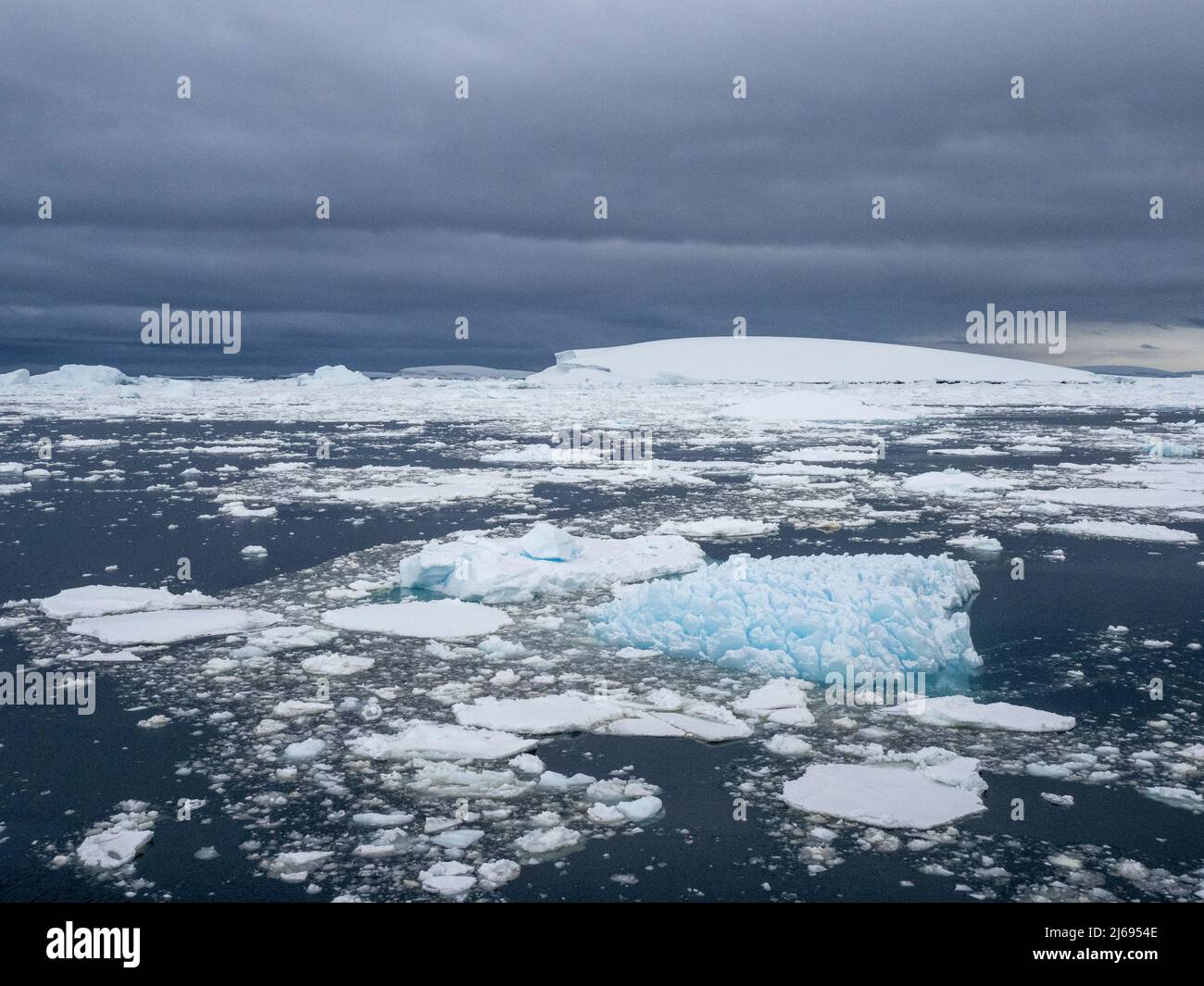 Stormy weather over pack ice and icebergs near Adelaide Island, Antarctica, Polar Regions Stock Photo