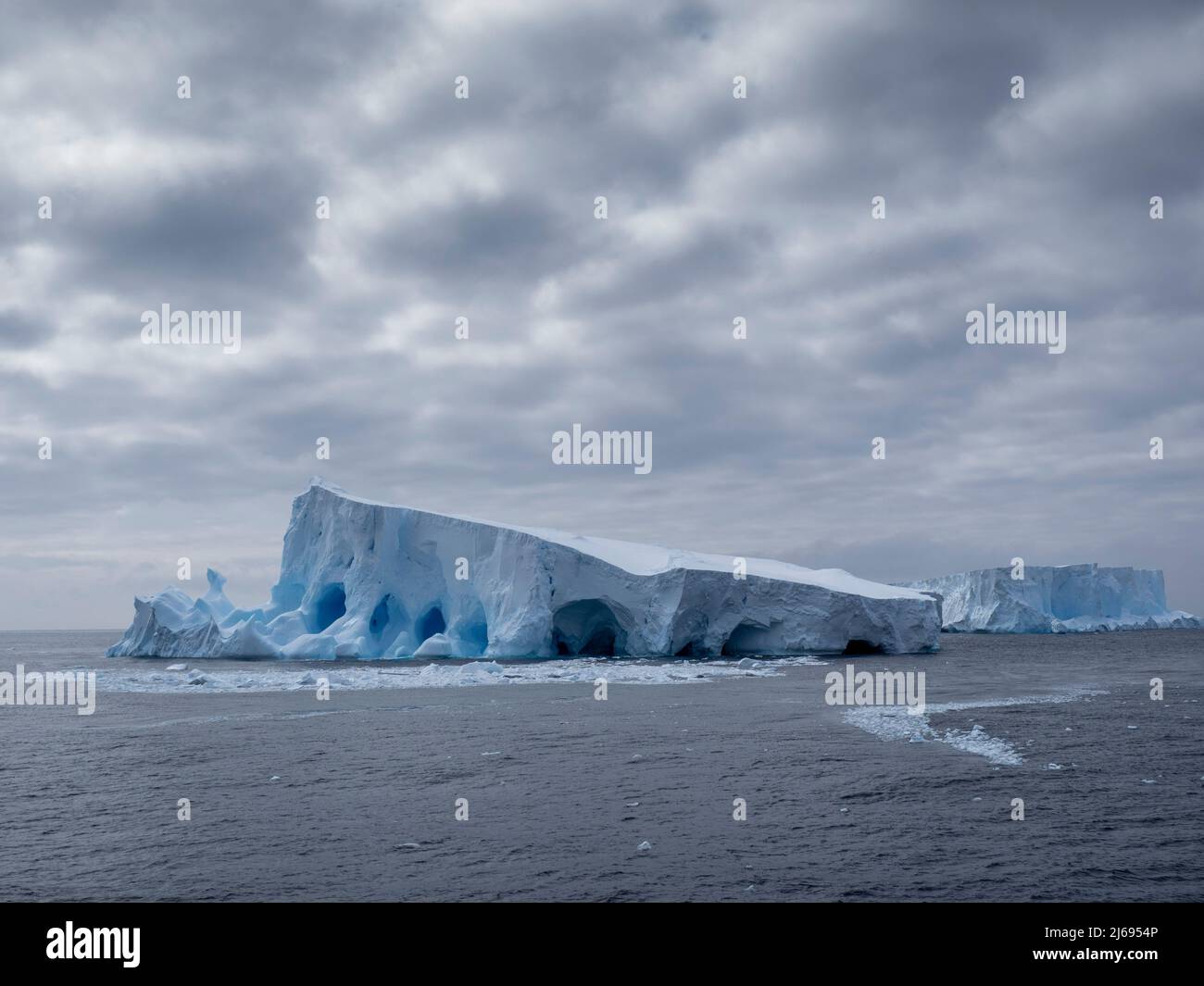 A large iceberg with holes and arches formed in it near Coronation Island, South Orkneys, Antarctica, Polar Regions Stock Photo